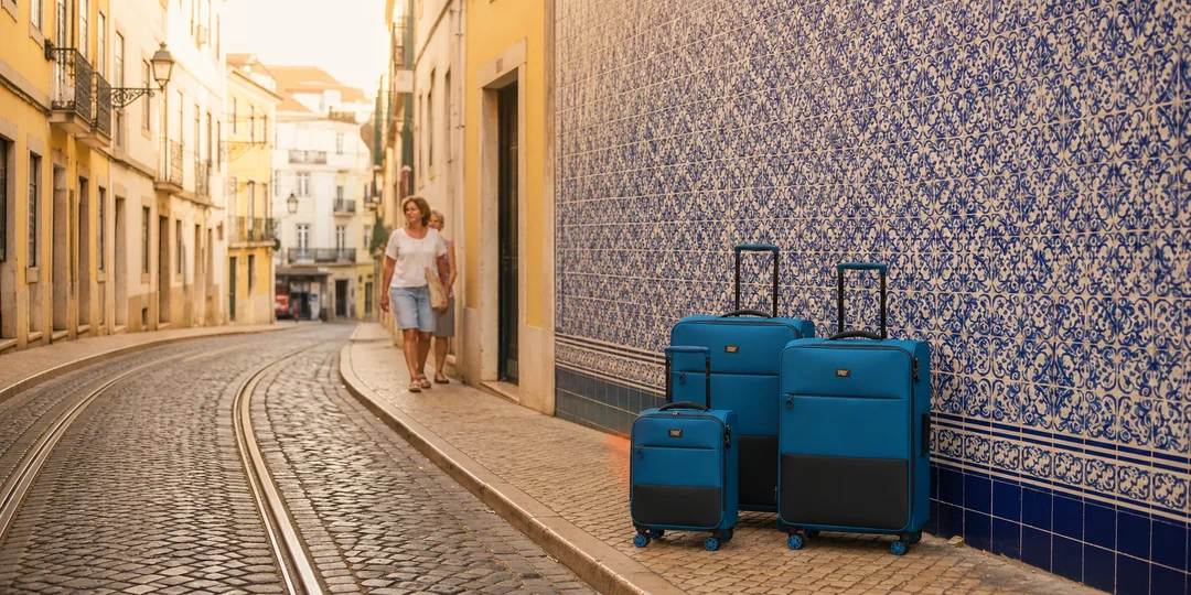 Blue CABIN FLUX softside luggage set by an azulejo-tiled wall in Lisbon